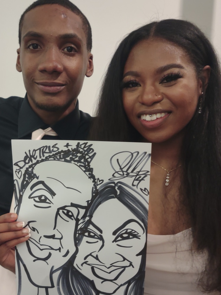 A couple holding up their wedding caricature