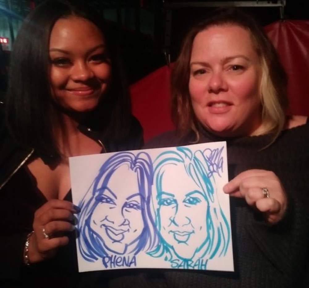 Two friends showing off their party caricature